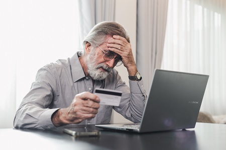 A man looking sad after a scam.